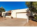 Beige single-story home with a large, attached two-car garage and a spacious driveway at 614 W Mcnair St, Chandler, AZ 85225