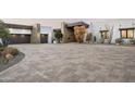 Expansive driveway leading to a modern home featuring stone accents and desert landscaping at 8822 E Chino Dr, Scottsdale, AZ 85255