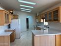 View of the kitchen featuring ample cabinetry, white appliances, and an arched doorway at 970 W Diamond Rim Dr, Casa Grande, AZ 85122