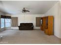 Bright living room featuring neutral carpet, a ceiling fan, and a comfortable sofa at 970 W Diamond Rim Dr, Casa Grande, AZ 85122