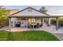 Spacious covered patio with seating, grill, and refrigerator perfect for outdoor entertaining and dining at 10594 E Wallflower Ln, Florence, AZ 85132