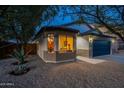 Well-maintained single-story home with neutral stucco exterior, a blue garage door, and low-maintenance landscaping at 10594 E Wallflower Ln, Florence, AZ 85132