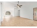 Spacious living room featuring tile flooring, arched window and sliding glass door leading to outdoor space at 1148 S Sierra St, Gilbert, AZ 85296