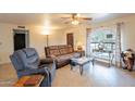 Inviting living room featuring comfortable seating, arched window, and ample natural light at 14493 S Country Club Dr, Arizona City, AZ 85123