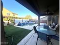 View of the pool from under the covered patio, features beautiful waterfalls and a spacious backyard at 17420 W Mohave St, Goodyear, AZ 85338