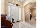 Inviting foyer with tiled flooring and a decorative glass window at 17813 W Primrose Ln, Surprise, AZ 85374