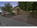 Inviting home with a three-car garage, a brick driveway, and manicured landscaping at 18256 W Carol Ave, Waddell, AZ 85355