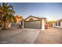 Single-story home with gray garage door, desert landscaping, and mature palm tree at 18359 N 88Th Ave, Peoria, AZ 85382