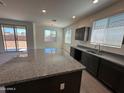 Modern kitchen featuring an island, granite countertops, and stainless steel appliances at 18783 N Avelino Dr, Maricopa, AZ 85138