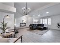 Spacious living room with vaulted ceiling, tile floors, and a modern chandelier at 19236 N 22Nd Ln, Phoenix, AZ 85027