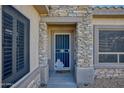 Inviting front entry features a secure screen door, decorative accents, and stone detailing at 19460 N Hidden Canyon Dr, Surprise, AZ 85374