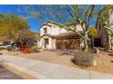 Beautiful two-story home featuring desert landscaping, a tiled roof, and brick paved driveway at 2406 W Tallgrass Trl, Phoenix, AZ 85085