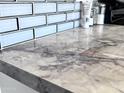 A close-up view of the kitchen countertop, showcasing the unique marble texture at 3328 W Charter Oak Rd, Phoenix, AZ 85029