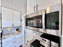 Well-lit kitchen featuring white cabinets, stainless steel microwave, and stylish countertops at 3328 W Charter Oak Rd, Phoenix, AZ 85029