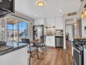 Bright kitchen featuring stainless steel appliances, white cabinetry, and an adjacent dining area at 3328 W Charter Oak Rd, Phoenix, AZ 85029