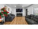 Spacious living room featuring wood flooring and a large television for entertaining guests at 3331 W Sells Dr, Phoenix, AZ 85017