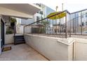 Condo exterior featuring a patio with a metal fence, patio furniture under an umbrella, and a staircase at 3416 N 44Th St # 70, Phoenix, AZ 85018