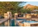 Resort-style pool area with stone waterfalls, built-in bar, and outdoor seating at 35530 N Canyon Crossings Dr, Carefree, AZ 85377