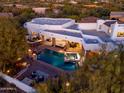 Aerial view of a backyard oasis featuring a sparkling pool, spa, and covered outdoor kitchen at 35530 N Canyon Crossings Dr, Cave Creek, AZ 85331