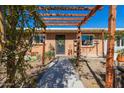 Charming front entrance with brickwork, pergola, landscaped walkway and decorative front door at 417 W Sunset Dr, Mammoth, AZ 85618