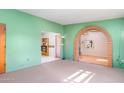 Spacious living room with archway, neutral carpet, green walls, and natural light at 417 W Sunset Dr, Mammoth, AZ 85618