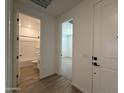 Bright hallway featuring doorways into a full bathroom and a carpeted bedroom at 4513 W 95Th Dr, Tolleson, AZ 85353