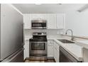 Well-equipped kitchen with stainless steel appliances, white cabinets, and sleek countertops at 510 N Alma School Rd # 103, Mesa, AZ 85201