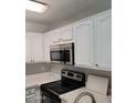 This is a bright kitchen with white cabinets and stainless steel appliances at 510 N Alma School Rd # 103, Mesa, AZ 85201