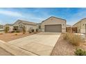 View of a single-story home with a neutral facade, complemented by a spacious driveway and desert landscaping at 5217 E Emery Rd, San Tan Valley, AZ 85143