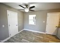 Cozy bedroom featuring light grey walls, stylish tile flooring, a ceiling fan, and two white doors at 6029 S 6Th Ave, Phoenix, AZ 85041