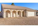 Charming single-story home featuring a two-car garage, low maintenance yard, and covered front entry with arched features at 6132 E Casper St, Mesa, AZ 85205