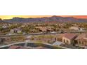 Aerial view of homes in a desert community with mountain views at sunset at 7165 S Bruins Rd, Gold Canyon, AZ 85118