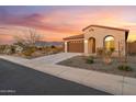 A single-Gathering home showing an attached two car garage and a beautifully landscaped yard at 7165 S Bruins Rd, Gold Canyon, AZ 85118