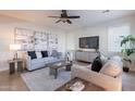 Bright living room with a ceiling fan, neutral color palette, and comfortable seating at 9556 W Frank Ave, Peoria, AZ 85382