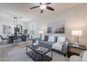 Cozy living room with a gray sofa, modern decor, and an open view to the dining area at 9556 W Frank Ave, Peoria, AZ 85382