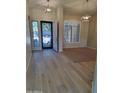 Inviting entryway showcasing light wood flooring and decorative front door with metalwork detail and modern lighting fixture at 104 W Windsong Dr, Phoenix, AZ 85045