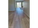 Bright living room showcasing luxury vinyl plank flooring and sliding glass doors to the backyard at 104 W Windsong Dr, Phoenix, AZ 85045