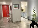 Stylish entryway featuring a bright red door, sleek console table, and a view into the modern kitchen at 1107 W Osborn Rd # 106, Phoenix, AZ 85013