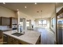 Open-concept kitchen featuring a large island with marble countertop, stainless steel appliances, and hardwood floors at 12870 E Rosewood Dr, Scottsdale, AZ 85255