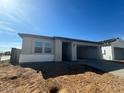 Modern single-Gathering home featuring a two-car garage and neutral color palette on a sunny day at 15749 W Beryl Ave, Waddell, AZ 85355