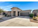 Attractive single-story home with a covered entryway, two-car garage, and well-maintained landscaping at 22443 E Munoz St, Queen Creek, AZ 85142