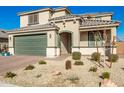 Two-story home boasting a green garage door, neutral stucco and decorative desert rock landscaping at 24578 W Concorda Dr, Buckeye, AZ 85326