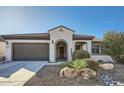 Exterior of a well-maintained home featuring a gray garage door and desert landscaping at 25925 W Mcrae Dr, Buckeye, AZ 85396