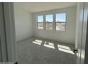 A bright bedroom featuring three large windows and neutral carpet, ready for personalization and comfort at 26361 N 76Th Dr, Peoria, AZ 85383