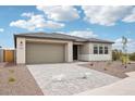 Exterior view featuring a two-car garage and covered entry of home with desert landscaping at 26361 N 76Th Dr, Peoria, AZ 85383