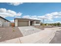 View of home's front yard featuring desert landscaping and a paved driveway leading to the two-car garage at 26361 N 76Th Dr, Peoria, AZ 85383