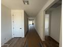Bright hallway features wood-look tile flooring and white doors, creating a clean and inviting transition between rooms at 26361 N 76Th Dr, Peoria, AZ 85383