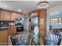 Eat-in kitchen featuring stainless steel appliances, wood cabinets, granite countertops, and a glass top dining table at 3321 E Almeria Rd, Phoenix, AZ 85008