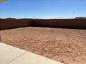 Spacious dirt backyard is surrounded by a block wall that allows for potential customization and privacy at 36805 W San Clemente St, Maricopa, AZ 85138