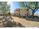 Exterior view of a multi-story condo with well-maintained lawn and mature shade trees at 5450 E Mclellan Rd # 133, Mesa, AZ 85205